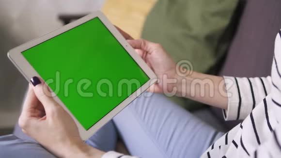 美国商界女性躺在家里的沙发上手里拿着一款绿色智能平板电脑视频的预览图