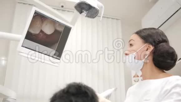 牙医用宏观相机检查患者口腔年轻的非裔美国男性牙科椅上的病人视频的预览图