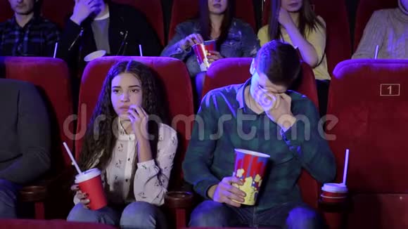 一群年轻人在电影院看一部悲伤的电影女孩在哭视频的预览图