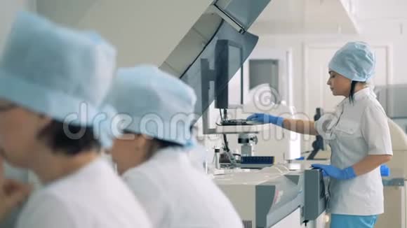 女医生控制着临床化学分析仪的功能视频的预览图