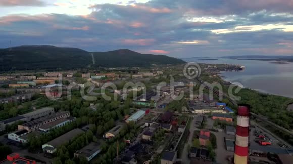 在典型的苏联北部城市上空飞行的无人机工厂管道城市街区和山丘的背景视频的预览图
