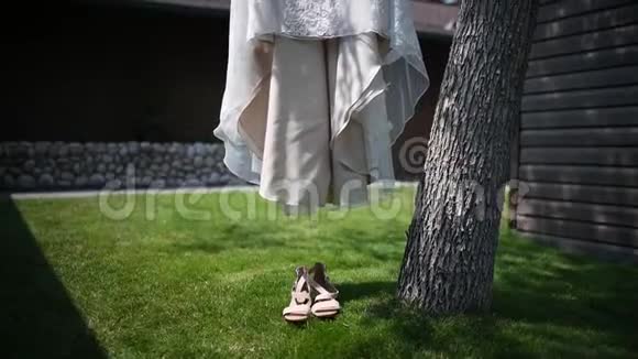 婚纱和鞋子挂在房子附近的一棵树上视频的预览图