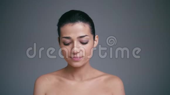 可爱的美眉年轻的黑发女人在灰色的背景下送气吻视频的预览图