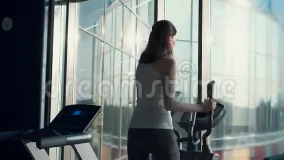 漂亮的运动女孩在窗前的一个时髦的健身房视频的预览图