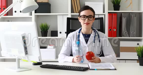医生手里拿着一瓶水和红苹果解释视频的预览图