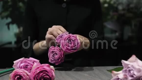 专业的花艺师把白色和红色的玫瑰花剪在桌子上女人的手特写视频的预览图