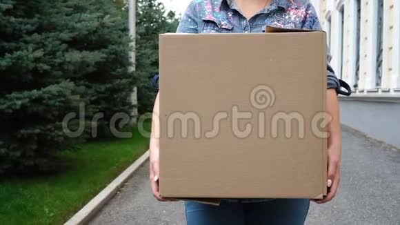 带着纸板箱的女人在户外散步视频的预览图