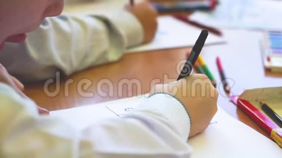 孩子坐在一张桌子旁用纸画画视频的预览图