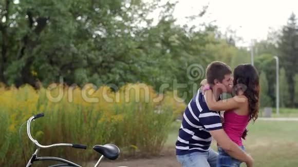 一对幸福的情侣在公园里相爱男人抬起并转过身去视频的预览图