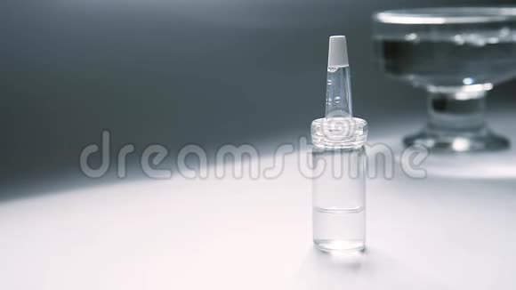 一个装有乳清的吸管的玻璃瓶在桌子上玻璃容器的背景是水的摇摆视频的预览图