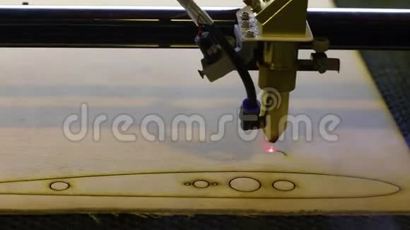 在激光数控机床上加工木制零件用数控机床从树上切下一个零件的过程红色视频的预览图