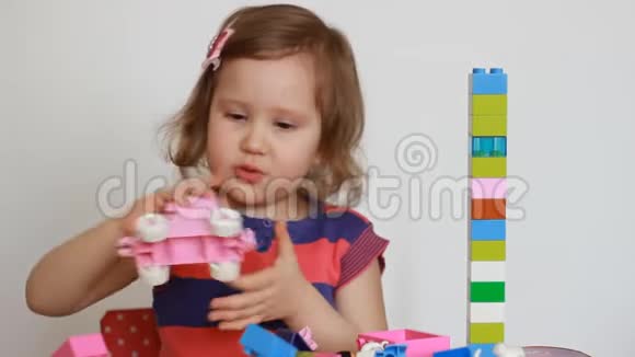 童女忙于建施工员宝贝在游戏中发展自己的思维和搭建能力视频的预览图