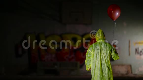 穿着斗篷的阴郁矮子站在后面手里拿着气球对着镜头视频的预览图