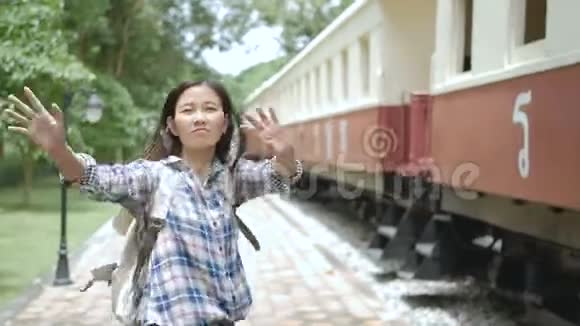4K亚洲女游客挥手告别离开火车站再见视频的预览图