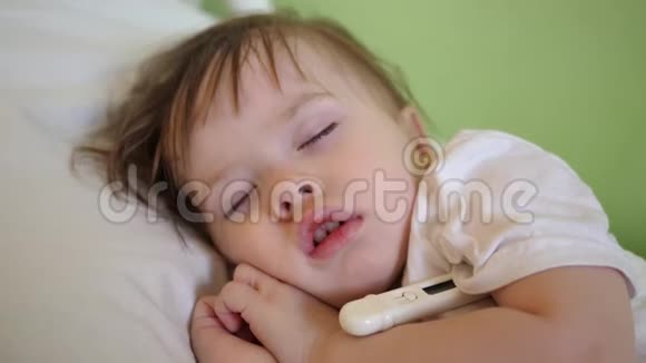 儿童体温在医院病房用体温计测量特写镜头婴儿睡在医院病房的白色床上视频的预览图