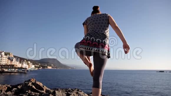 年轻健康的女性在日出时在海滩上练习瑜伽自然环境对身体的好处视频的预览图