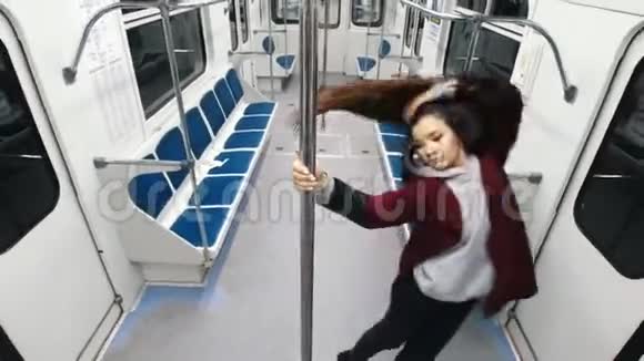 年轻女子在火车上跳钢管舞跳在钢管上挂在上面视频的预览图