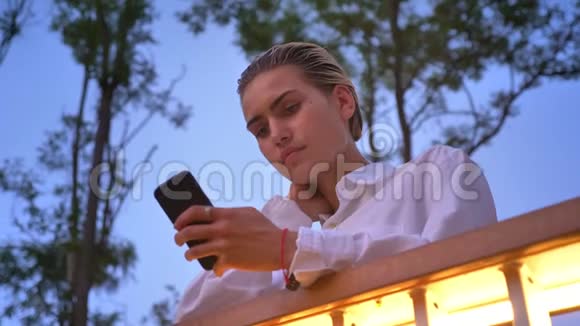 年轻的现代女性站在桥上在智能手机上输入信息交流观念放松观念底层视频的预览图