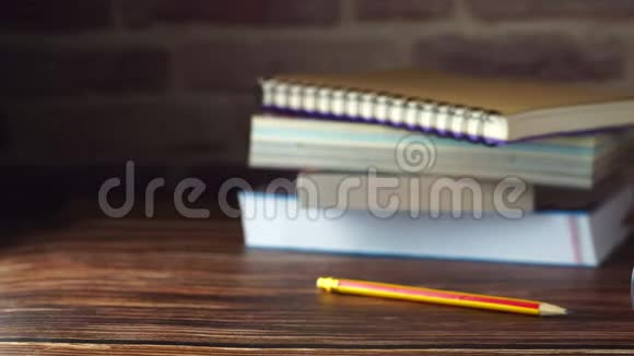 多莉沙漏铅笔和书堆放在木桌上视频的预览图