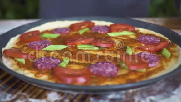 生的意大利披萨上面有西红柿意大利香肠和青豆意大利比萨饼手做比萨饼视频的预览图