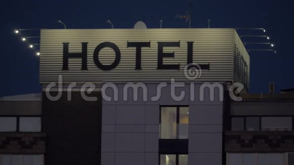 一个酒店标志在一座建筑的顶部顶着漆黑的夜空视频的预览图