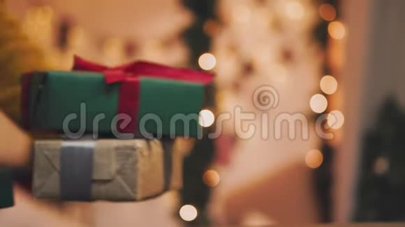 圣诞节的主题年轻女子把礼物放在圣诞树下在散焦中视频的预览图