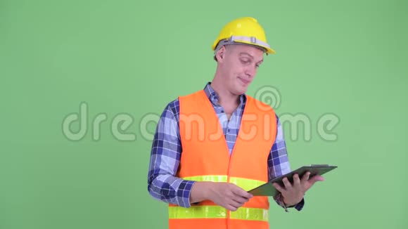 幸福的青年建筑工人一边指挥一边拿着剪贴板视频的预览图