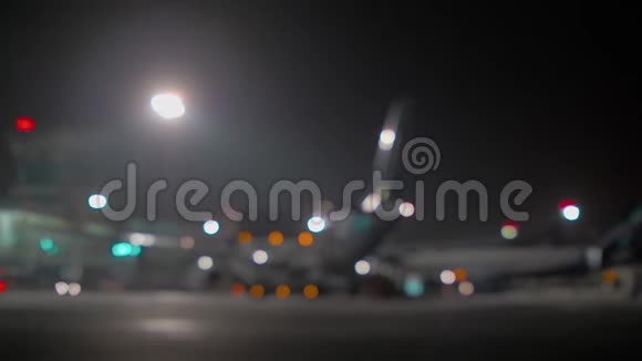 夜间机场候机楼的模糊飞机视频的预览图
