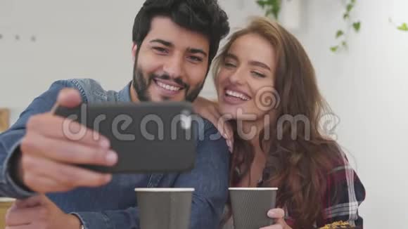 美丽的情侣在咖啡厅打电话拍照视频的预览图