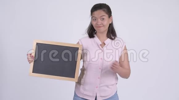 年轻快乐的亚洲女商人拿着黑板竖起大拇指视频的预览图