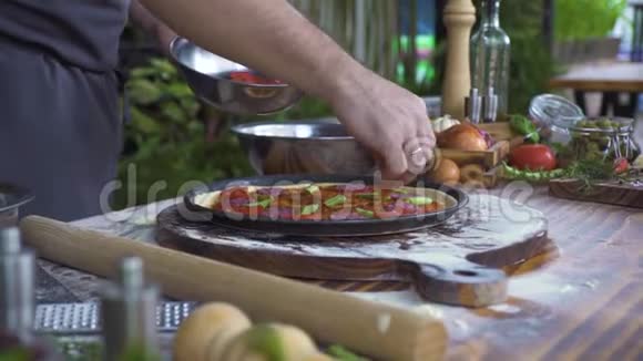 厨师用香肠和西红柿在厨房桌子上准备披萨食物背景意大利披萨店做披萨视频的预览图