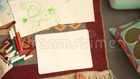 小女孩在纸上画画从顶部查看视频的预览图