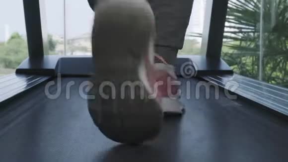 在健身房的跑步机上用粉红色的运动鞋把女人的腿收起来滑动相机向前移动漂亮的腿这就是视频的预览图