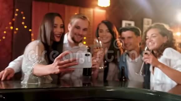 年轻开朗的女性朋友用电话在酒吧里自拍朋友男人女人休闲友谊和科技视频的预览图