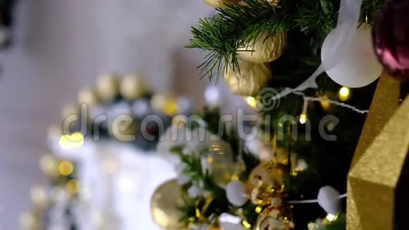 在Chrismas树上合上金色玩具在背景上闪烁仙女的光芒视频的预览图