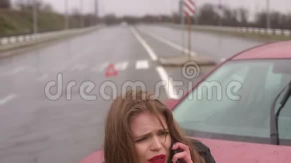在雨中发生车祸后吓坏了的女孩打电话车坏了视频的预览图
