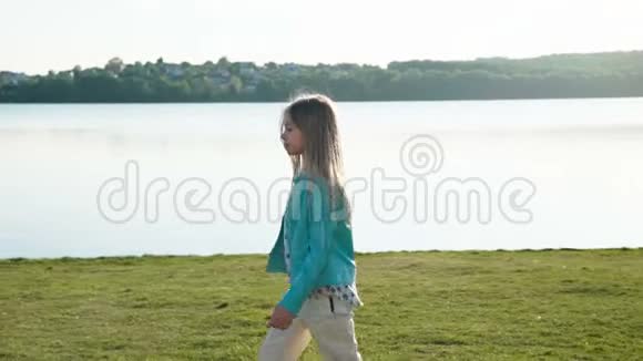 美丽的小女孩在阳光明媚的码头在镜头前跑来跑去慢慢地视频的预览图