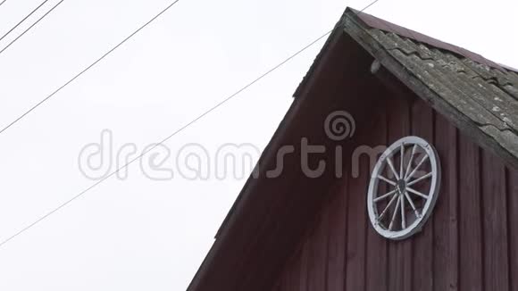 旧木村房屋墙附近的旧车轮视频的预览图