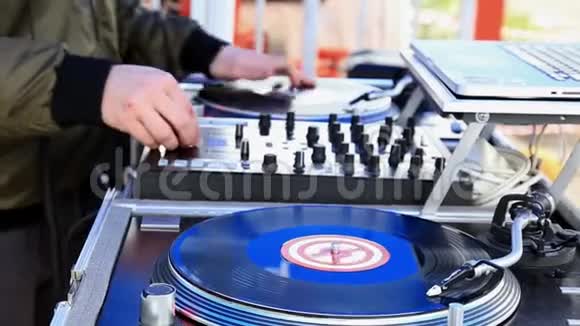 DJ播放音乐在露天派对上观看转盘上的乙烯基记录双手特写视频的预览图