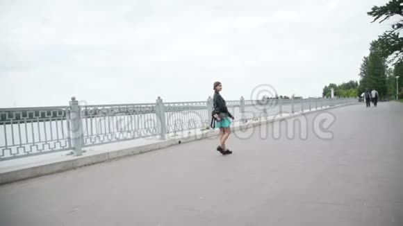 快乐的年轻女孩穿着滑稽的走着在码头上的镜头前摆姿势视频的预览图
