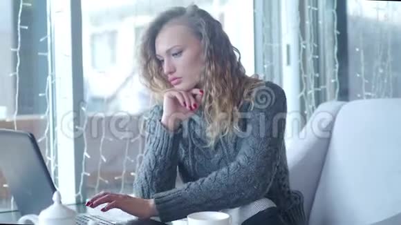 一个女人在咖啡店用平板电脑打字的特写镜头视频的预览图