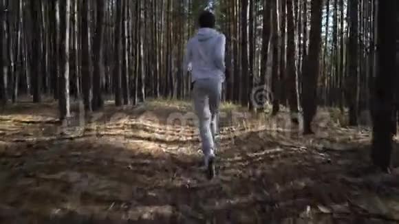 小男孩在树林路上慢跑视频的预览图