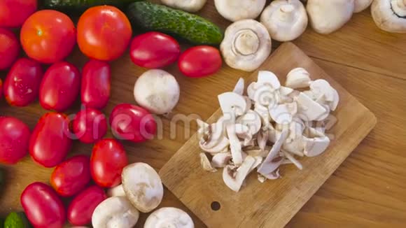 用不同的蔬菜在厨房桌子上的木板上切蘑菇香姜片视频的预览图