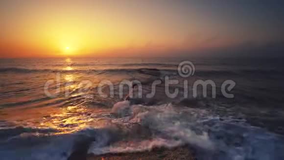 美丽的日出越过大海和海滩当太阳从地平线升起时海浪在飞舞视频的预览图