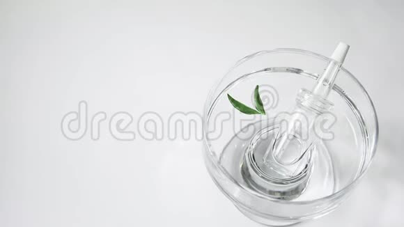 一个装有乳清的吸管的玻璃瓶在桌子上玻璃容器的背景是水的摇摆视频的预览图