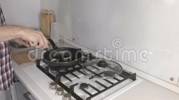 男人正在煎锅里用香肠准备炒鸡蛋双手特写视频的预览图