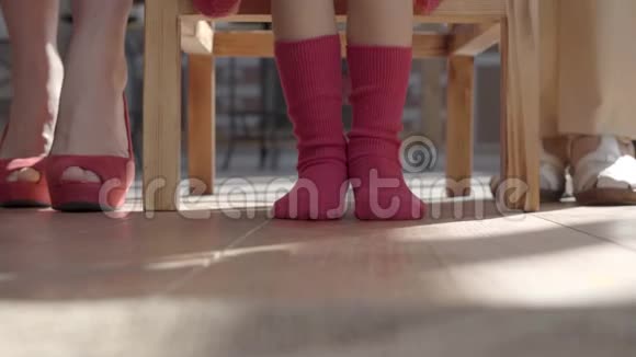 妈妈小女儿和奶奶的腿女人穿着红色的鞋子女孩的长袜和奶奶的米色凉鞋视频的预览图