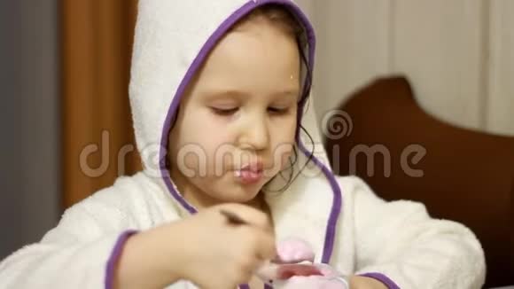 小女孩用勺子吃奶酪孩子吃乳制品酸奶肖像特写视频的预览图