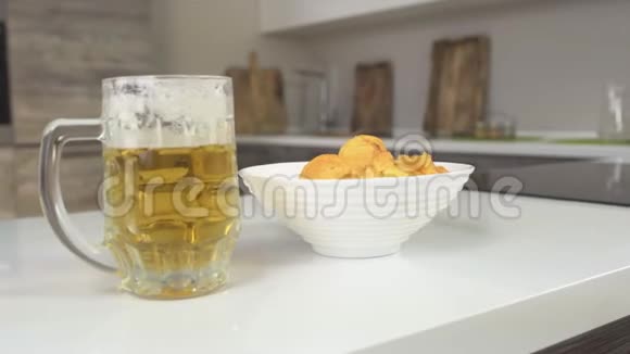 厨房里有一杯啤酒和一盘薯片肥胖和啤酒复印空间视频的预览图