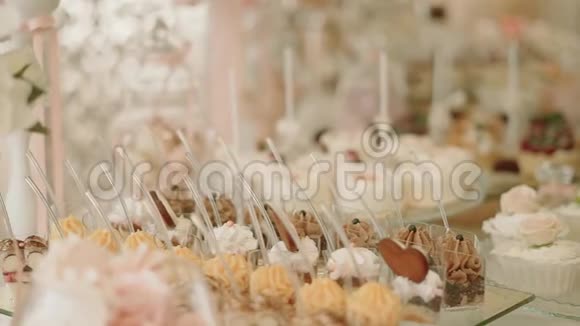 白色糖果酒吧婚礼婚礼糕点在甜桌糖果自助餐关闭移动摄像机视频的预览图